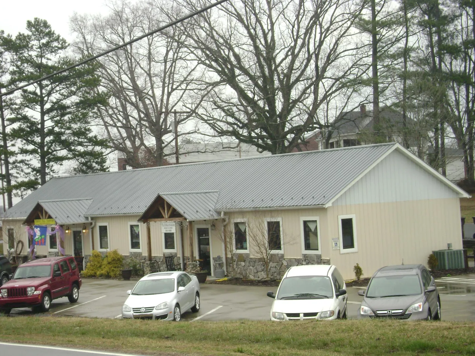 Gray metal roof with timber entry brackets on a small commercial building in Lanoka Harbor