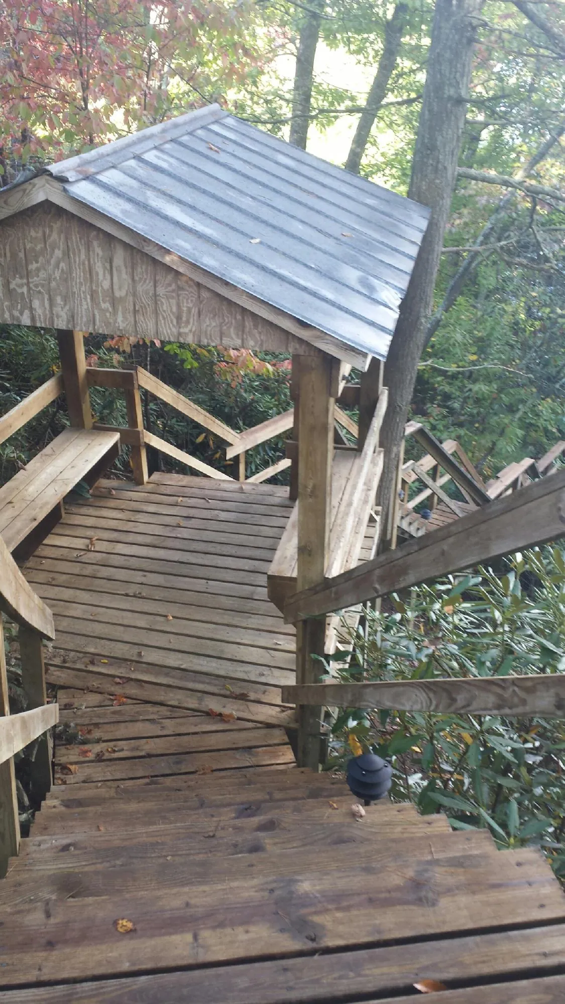 Metal roofed shelter over wooden steps on a wooded walkway — Skylight Repair & Installation work by our crew in Lanoka Harbor